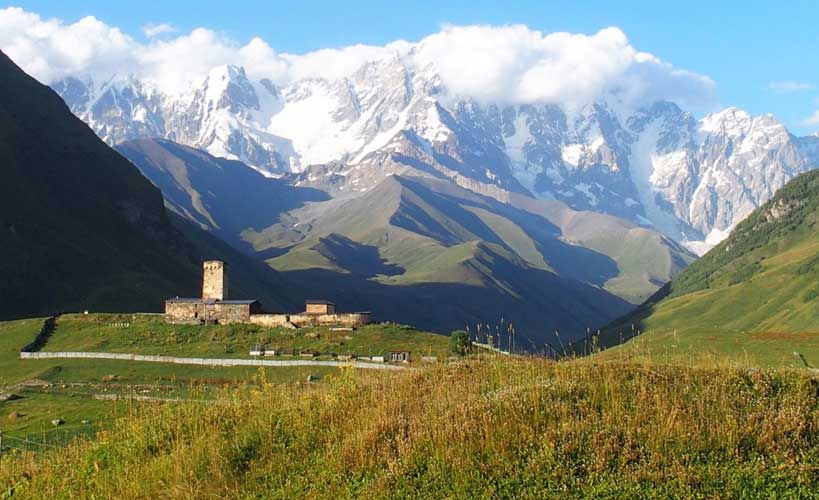 La Maria church Ushguli with spectacular snow capped mountains - georgia armenia azerbaijan tours