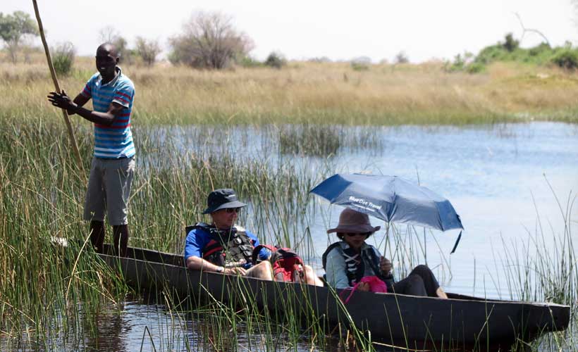 Dug out canoes gliding through the Okavanga Delta Botswana