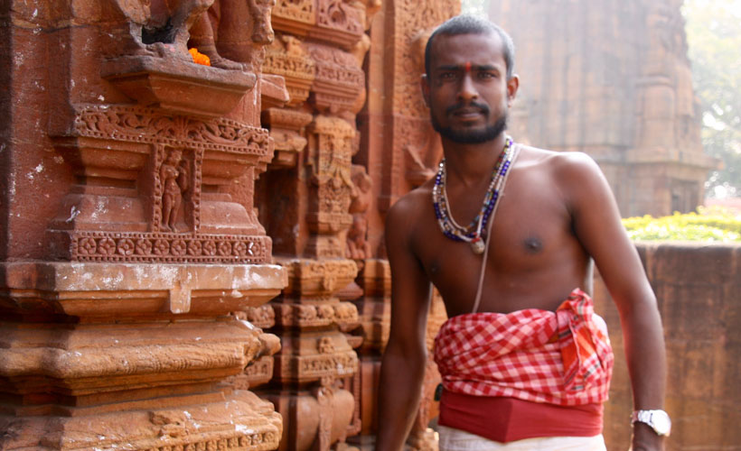 Young Indian man standing in front of temple